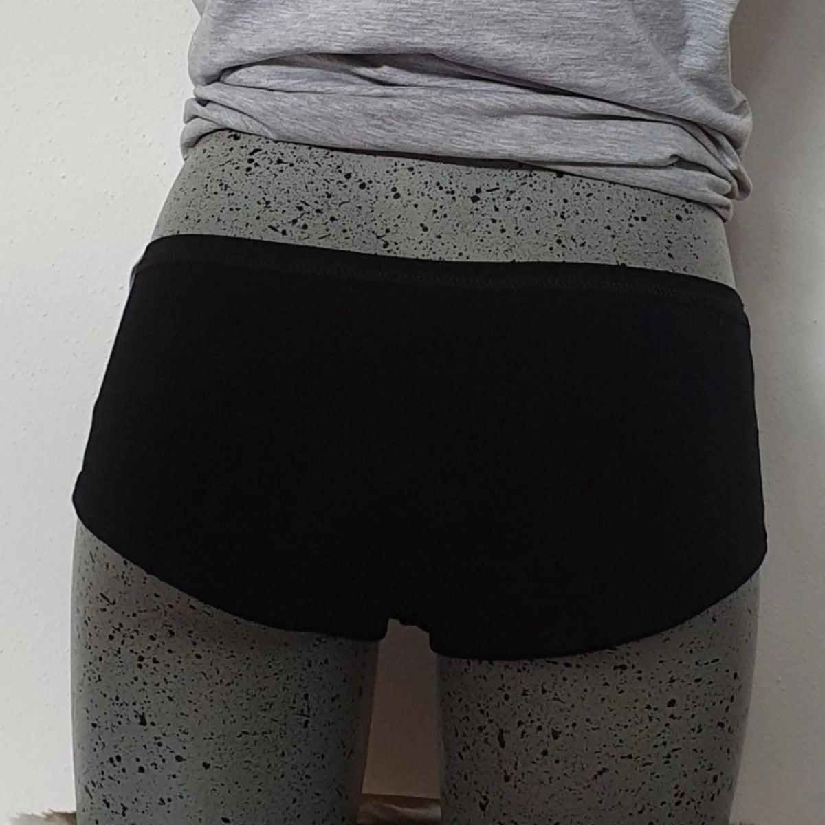 Hipster met hartje en naam: zwarte hipster van achteren gezien, gedragen met een grijze legging
