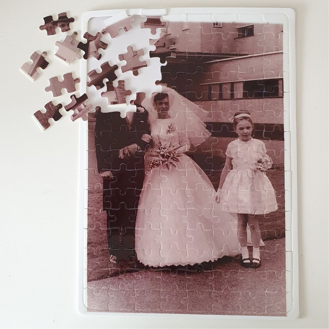 Foto puzzel: puzzel met een oude trouwfoto van een bruidspaar met een meisje, met losse stukjes